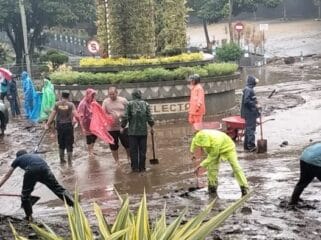 Polsek Bumiaji Polres Batu bersama BPBD Kota Batu, Koramil Bumiaji, dan relawan serta warga saat bergotong royong membersikan luapan air lumpu di Selecta. (Foto : Istimewa)