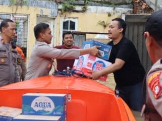 Jajaran Polri saat memberikan bantuan kepada salah seorang korban banjir. (Foto : Humas Polri)