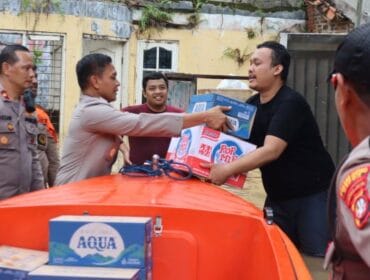 Jajaran Polri saat memberikan bantuan kepada salah seorang korban banjir. (Foto : Humas Polri)