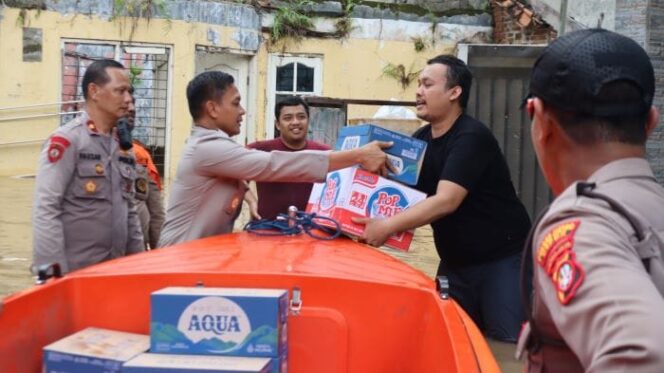 
					Jajaran Polri saat memberikan bantuan kepada salah seorang korban banjir. (Foto : Humas Polri)