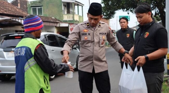 Jajaran Sat Reskrim Polres Batu saat membagikan Takjil gratis kepada salah seorang supeltas . (Foto : Humas Polres Batu)