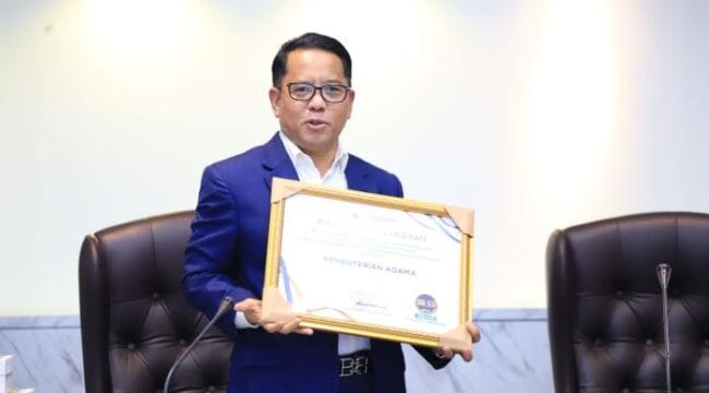 Sekretaris Jenderal Kemenag RI, Kamaruddin Amin saat menerima Piagam penghargaan  (Foto : Humas Kemenag)