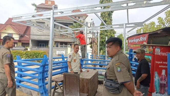 
					Petugas Trantib Ciledug saat membongkar bangunan liar diatas lahan penampungan air. ( Foto : Tangerangkota.co.id)