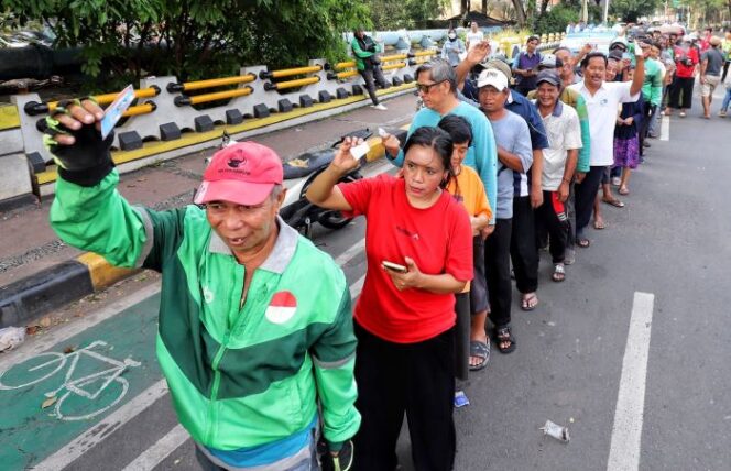
					Ratusan warga saat mengantri untuk mendapatkan paket beras gratis . (Foto : Gunawan)