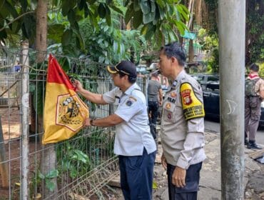 salah seorang petugas gabungan saat menertibkan salah satu bendera ormas .(Foto : Humnas Polres Jakpus)