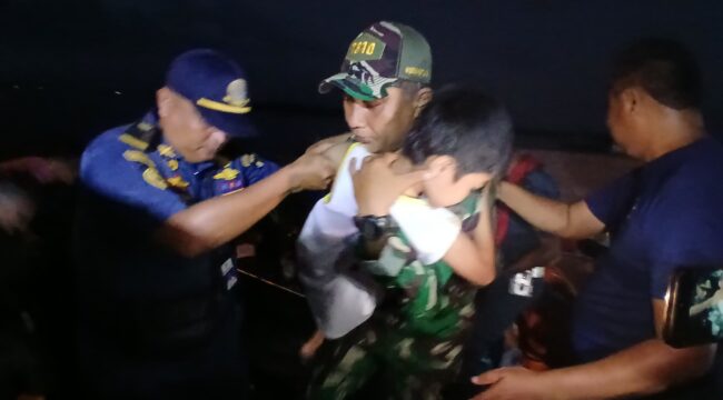 Seorang Prajurit TNI AL, saat mengecvakuasi anak kecil korban terbakarnya KM Barcelona  (Foto : Puspenk TNI )
