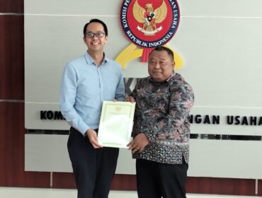 Ketua Sidang Komisi KPPU Budi Joyo Santoso daat menyerahkan dokumen penetapan Program Kepatuhan Persaingan Usaha Kepada Presiden Direktur PT PLI Wen Krisnadi (Foto : Sirhan)