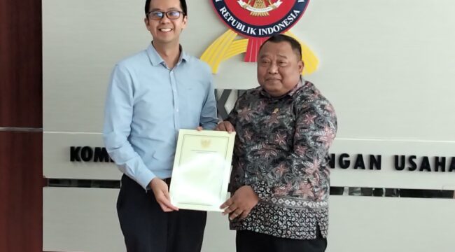 Ketua Sidang Komisi KPPU Budi Joyo Santoso daat menyerahkan dokumen penetapan Program Kepatuhan Persaingan Usaha Kepada Presiden Direktur PT PLI Wen Krisnadi (Foto : Sirhan)