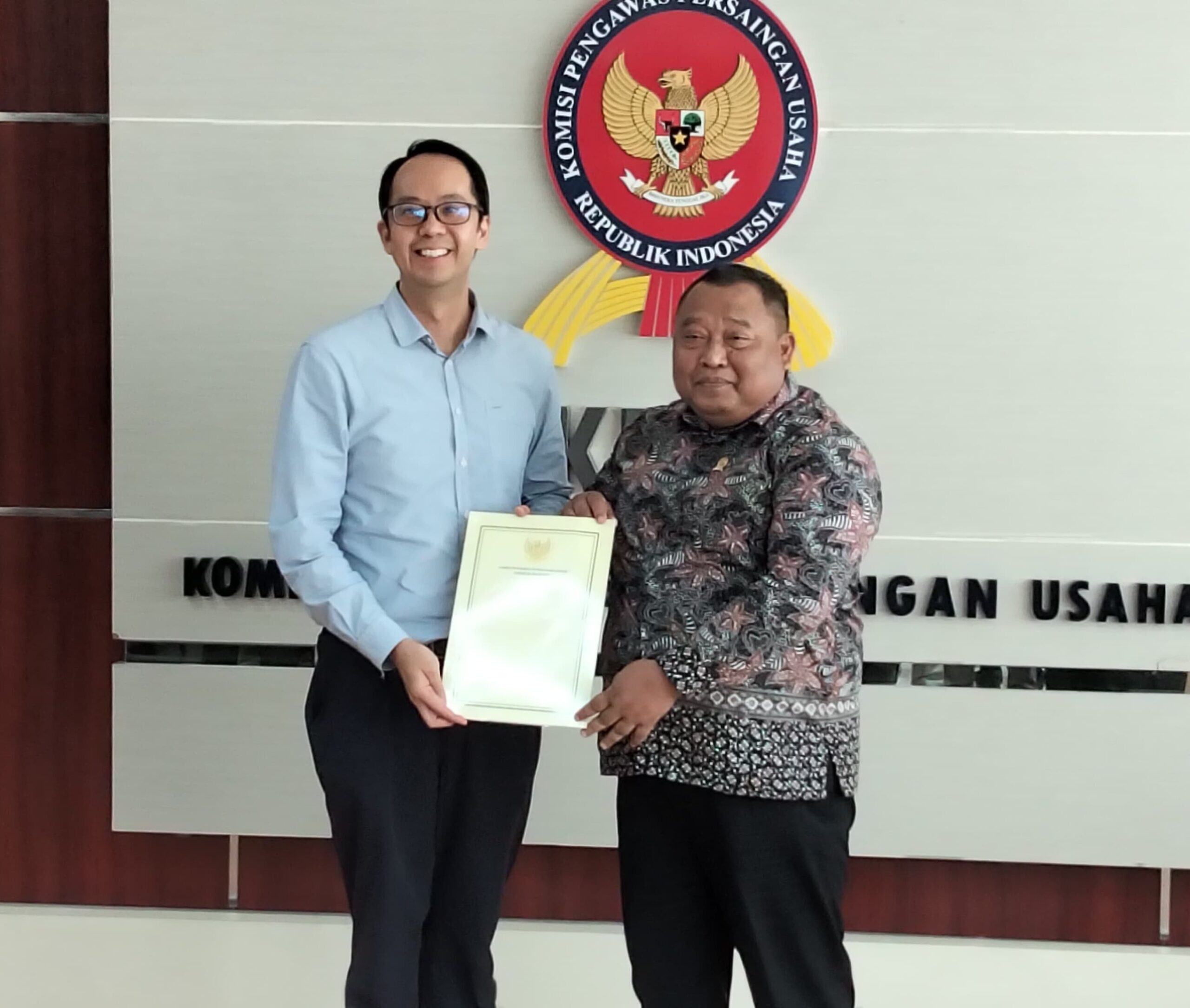 Ketua Sidang Komisi KPPU Budi Joyo Santoso daat menyerahkan dokumen penetapan Program Kepatuhan Persaingan Usaha Kepada Presiden Direktur PT PLI Wen Krisnadi (Foto : Sirhan)
