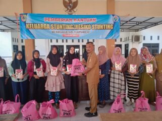 Kepala Desa Tempurejo, saat memberikan bantuan kepada warga beresiko stunting (Foto: Kominfo Jember)