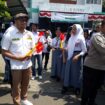 Kordinator kegiatan dari karang taruna, Iwan Pristiasya saat membagian bendera merah putih. (Foto: Istimewa)