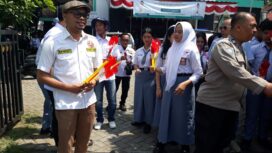 Kordinator kegiatan dari karang taruna, Iwan Pristiasya saat membagian bendera merah putih. (Foto: Istimewa)