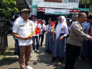 Kordinator kegiatan dari karang taruna, Iwan Pristiasya saat membagian bendera merah putih. (Foto: Istimewa)