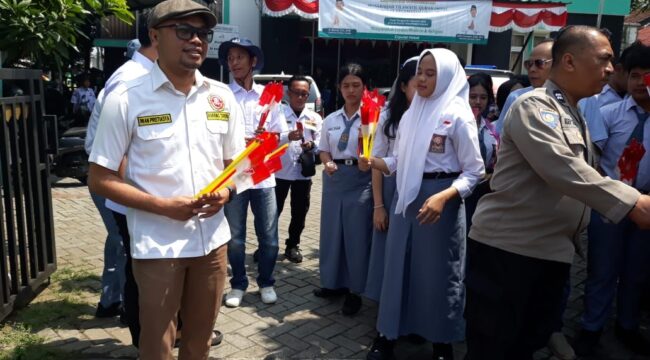 Kordinator kegiatan dari karang taruna, Iwan Pristiasya saat membagian bendera merah putih. (Foto: Istimewa)