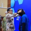 Wakil Menteri Ketenagakerjaan, Immanuel Ebenezer Gerungan saat mengalungkan tanda pengenal Layanan kewirausahaan 2025 (Foto : Humas Kemnaker)