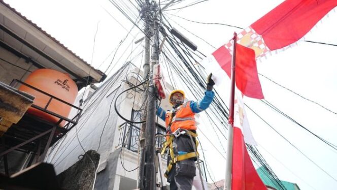 
Salah seorang petugas PLN sedang merapikan bendera yang mengenai kabel listrik. (Foto : PLN Jakarta Raya)