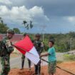 Prajurit Satgas Yonif 126/Kalacakti bersama dengan warga memasang bendera merah putih. (Foto : Puspen TNI) 
