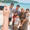 Ilustrasi menikmati liburan bersama keluarga di pantai (Foto: Lmarena AI)