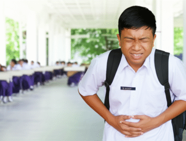 Ilustrasi anak sekolah sedang merasakan sakit perut diduga setelah santap menu MBG (lmarena ai)