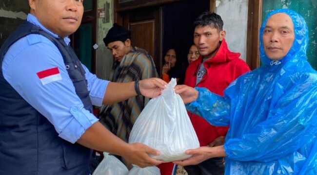 Petugas BGN saat memberikan bantuan paket MBG kepada salah seorang korban banjir di Tapanuli Selatan. (Foto : Humas BGN)