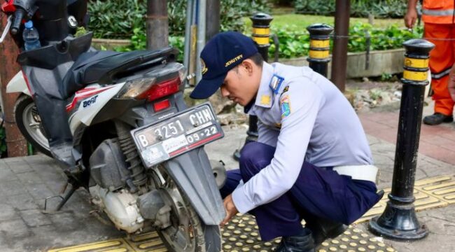 Salah seorang pertugas Dishub saat menindak sepeda motor yang parkir sembarangan dalam rangka Razia Rabu Tertib. (Foto : Kominfotik)