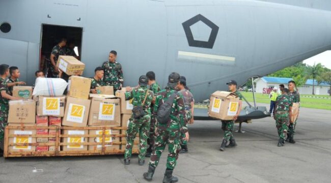 Para Prajurit TNI saat measukan lositik bantuan ke pesawat . (puspen TNI)