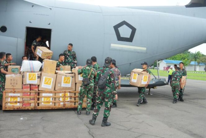 
					Para Prajurit TNI saat measukan lositik bantuan ke pesawat . (puspen TNI)