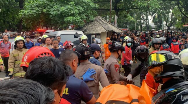 Para petugas kepolosian saat mengevakuasi korban meninggal akibat kebakaran Gedung Terra Drone Kemayoran Jakarta. (Foto : Humas Brimob)