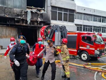 Petugas kepolisian saat mengevakuasi korban dari lokasi kebakaran Gedung Terra Drone. (Foto : Humas Brimob)