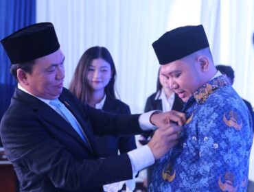 Ketua KPPU Fanshurullah Asa  saat menyematkan Pin ke salah Satu ASN yang dilantik. (Foto : KPPU)