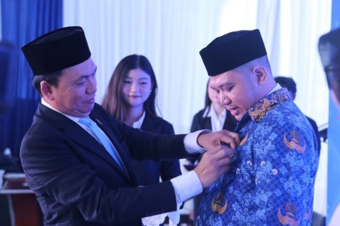 
					Ketua KPPU Fanshurullah Asa  saat menyematkan Pin ke salah Satu ASN yang dilantik. (Foto : KPPU)