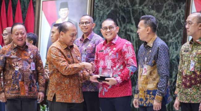 Sekda Pemprov DKI Jakarta Uus Kuswanto saat meberikan plakat penghargaan kepada Wali Kota Jakarta Pusat Arifin. (Foto : Kominfotik Jakpus)