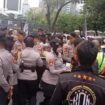 Aksi Polwan Polda Metro Jaya saat membegikan air kemasan kepada para peserta demo Ojol. (Foto : Humas Polda Metro Jaya)
