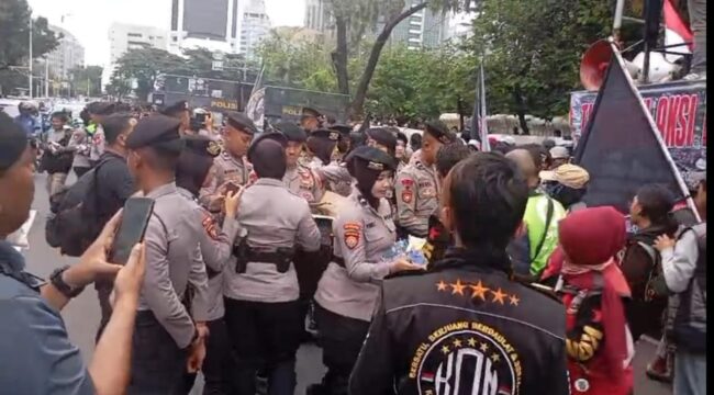 Aksi Polwan Polda Metro Jaya saat membegikan air kemasan kepada para peserta demo Ojol. (Foto : Humas Polda Metro Jaya)