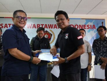 Sekretaris Umum PWI Jaya, Arman Suparman saat menyerahkan Piagan OKK dan Kartu Anggota Kepada peserta OKK. (Foto : PWI Jaya)