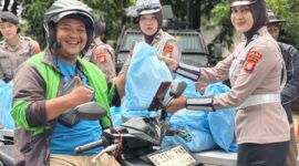 Polwan PMJ saat membagikan paket sembako ke salah satu pengguna ojol. (Foto: Humas PMJ)